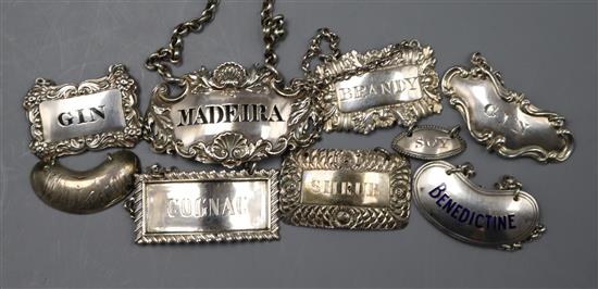 Eight assorted 19th and 20th century silver wine labels and a silver condiment label.